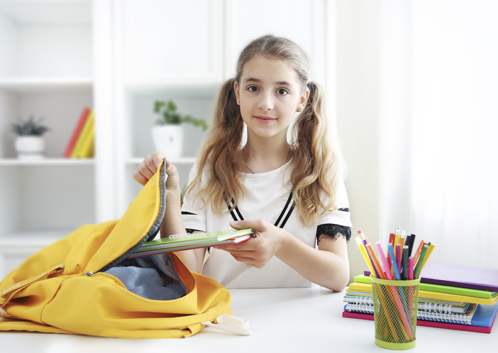 niña preparando la mochila para el colegio
